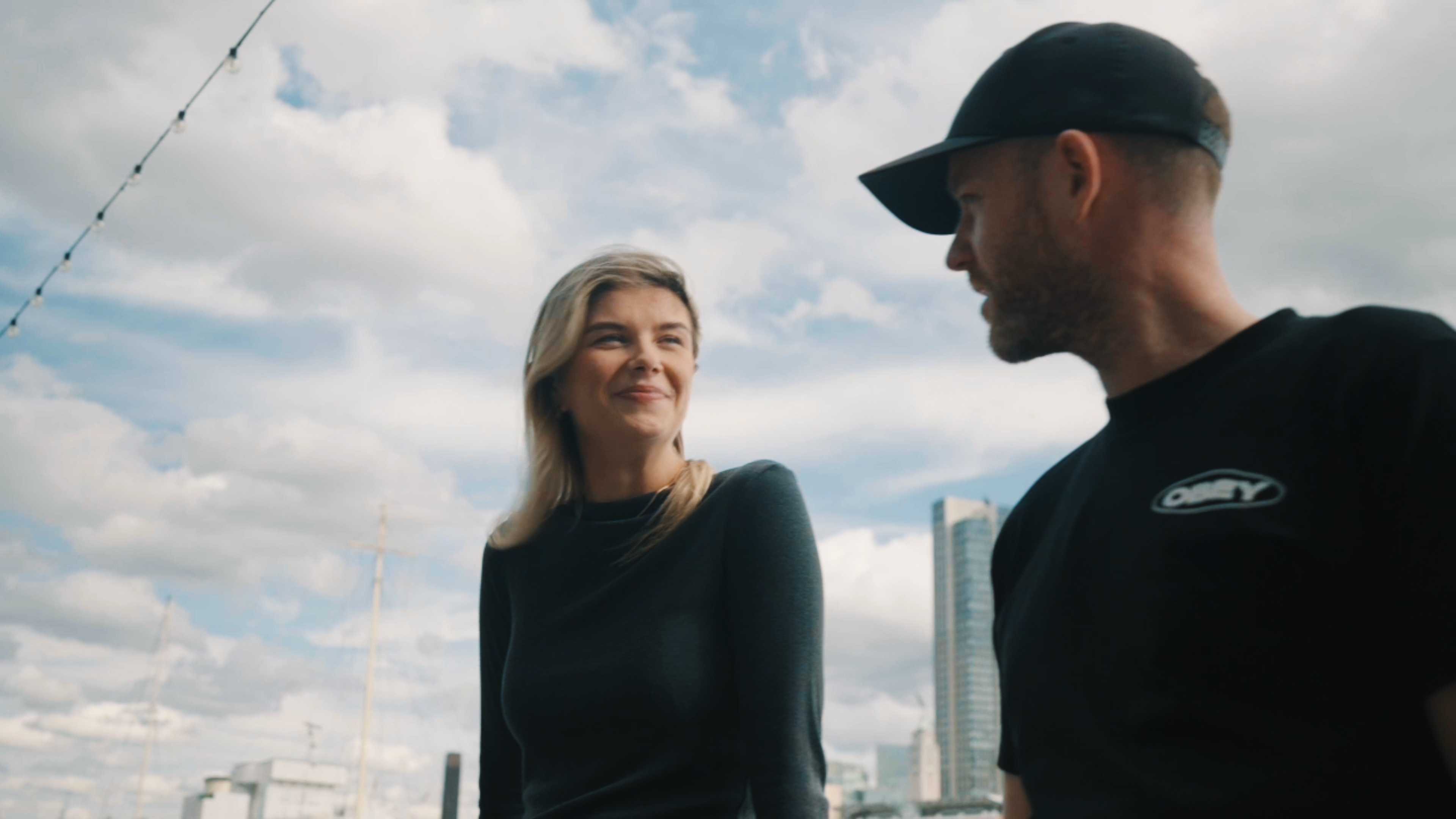 Olivia Flanagan and Ross Keating speaking against the London skyline